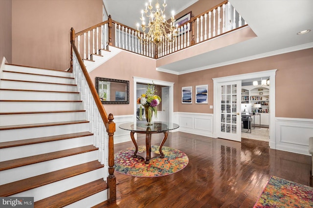 entryway with crown molding, dark hardwood / wood-style floors, and a chandelier