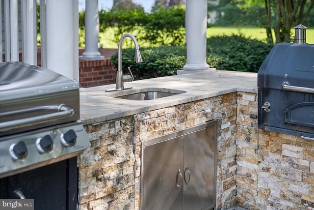 view of patio with area for grilling, a grill, and sink