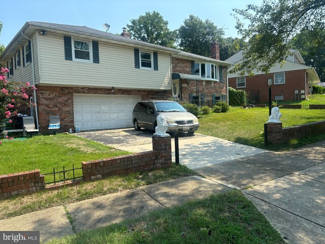 raised ranch with a garage and a front lawn