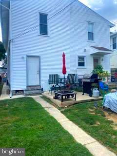 back of property with a patio and a lawn