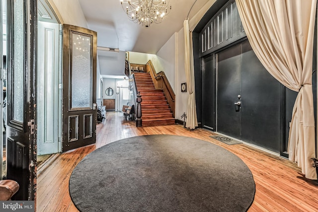 entryway with stairs, a chandelier, and hardwood / wood-style flooring