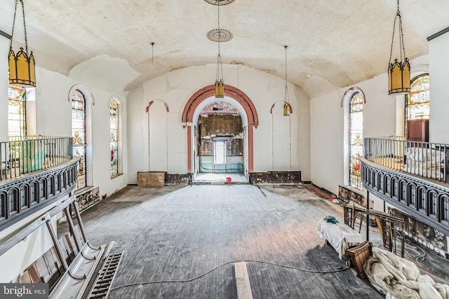 miscellaneous room with wood-type flooring, vaulted ceiling, and baseboards