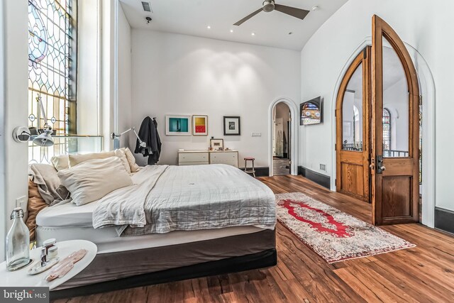 bedroom with arched walkways, recessed lighting, and wood finished floors