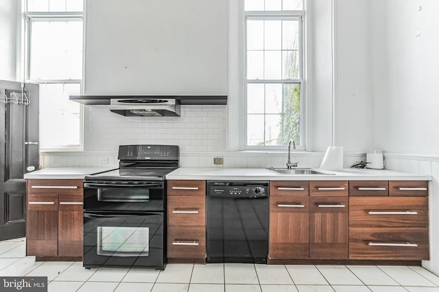 kitchen with a sink, black appliances, modern cabinets, and light countertops