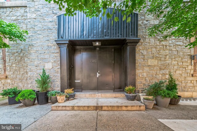 doorway to property featuring stone siding