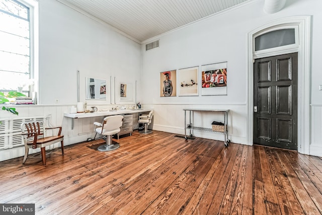 sitting room featuring a wainscoted wall, ornamental molding, wood-type flooring, and visible vents