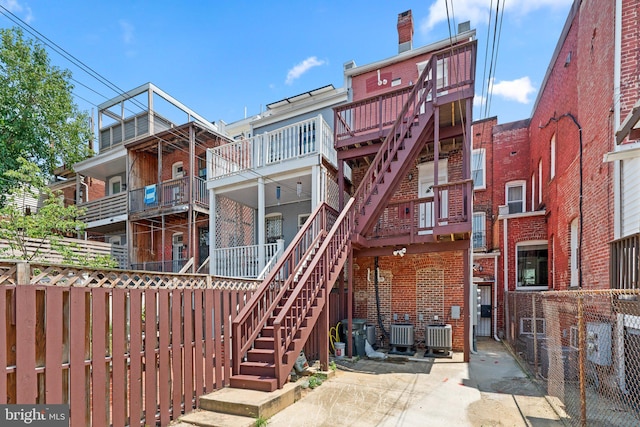 rear view of house featuring a balcony and central AC unit