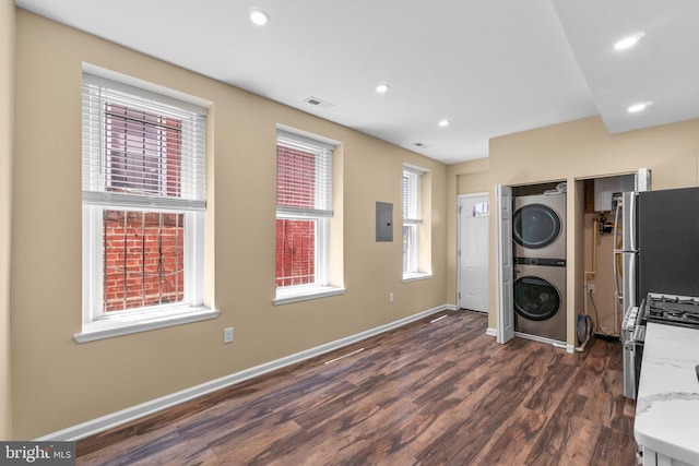 kitchen featuring range, stainless steel refrigerator, stacked washing maching and dryer, dark wood-type flooring, and electric panel