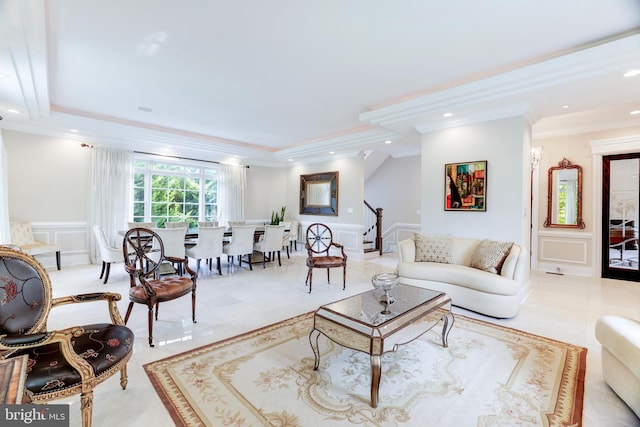 tiled living room featuring a raised ceiling and ornamental molding