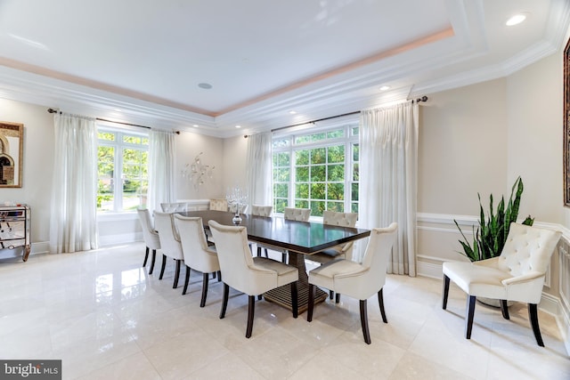 dining space featuring a raised ceiling and crown molding