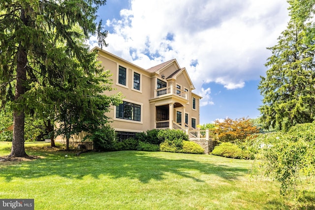 exterior space with a balcony and a lawn