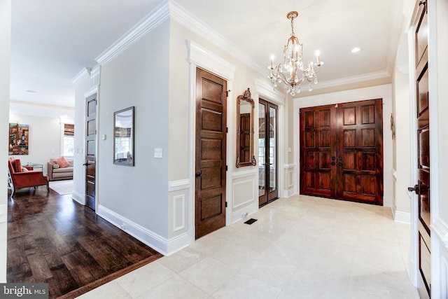 foyer entrance featuring ornamental molding and a notable chandelier