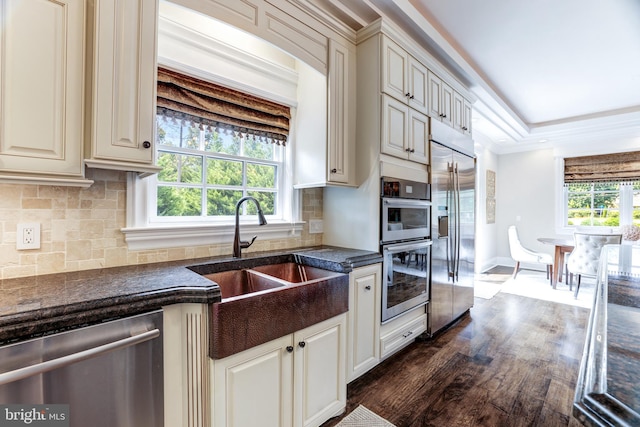 kitchen with stainless steel appliances, sink, a wealth of natural light, and backsplash