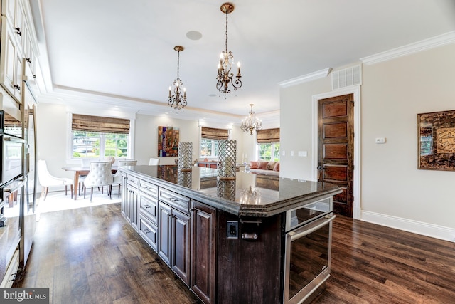 kitchen with an inviting chandelier, dark brown cabinets, a center island, dark hardwood / wood-style flooring, and oven