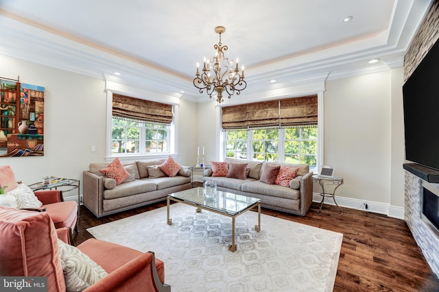 living room featuring a raised ceiling, crown molding, dark hardwood / wood-style floors, and a chandelier