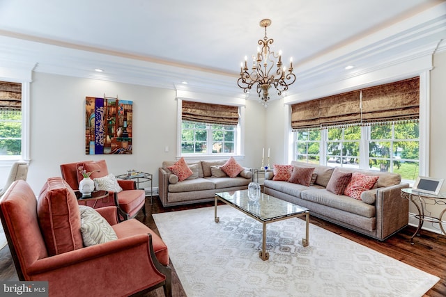 living room with dark hardwood / wood-style flooring, crown molding, and an inviting chandelier