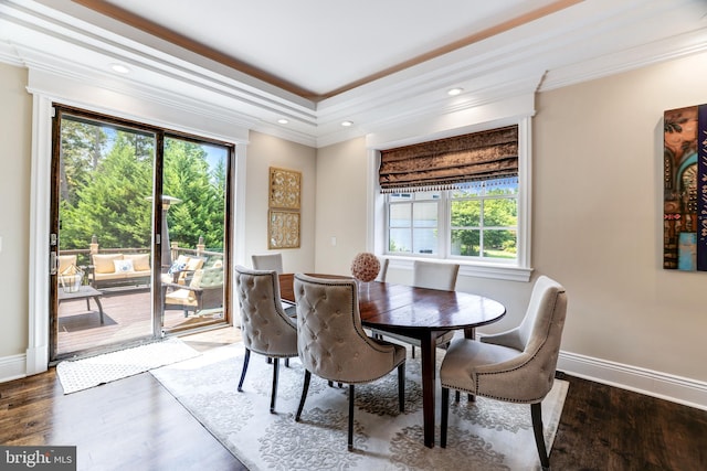 dining area with ornamental molding and dark hardwood / wood-style flooring