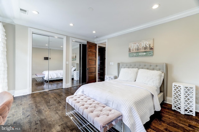 bedroom with multiple closets, crown molding, and dark hardwood / wood-style flooring