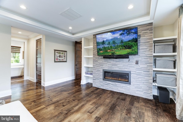 unfurnished living room featuring dark hardwood / wood-style flooring, built in shelves, and a raised ceiling