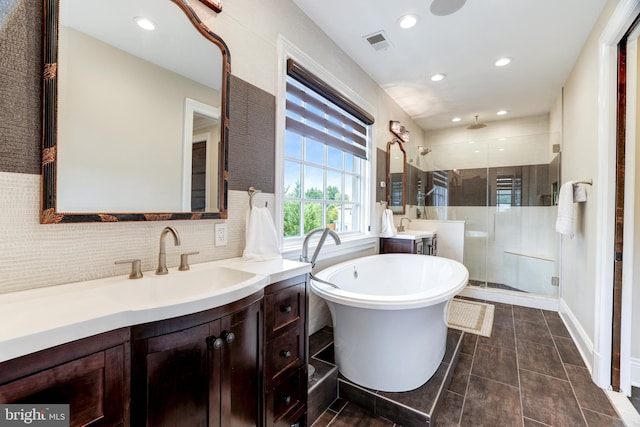 bathroom featuring vanity, tile patterned flooring, tasteful backsplash, and plus walk in shower