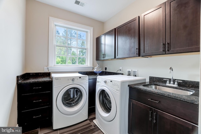 laundry area featuring cabinets, dark hardwood / wood-style floors, washer and clothes dryer, and sink