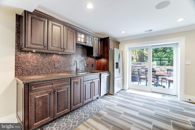 kitchen featuring tasteful backsplash, sink, stainless steel appliances, and dark brown cabinetry