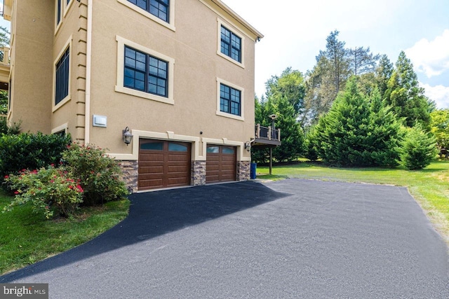 view of side of property featuring a garage and a lawn