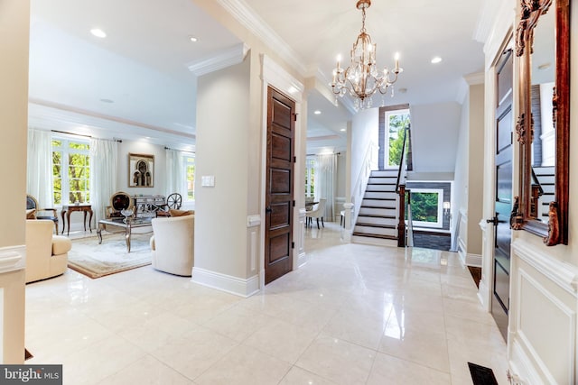 foyer featuring a notable chandelier, ornamental molding, and light tile patterned floors