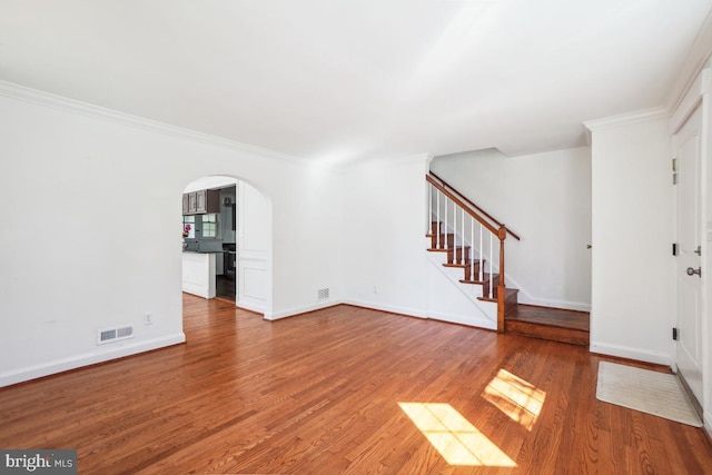 unfurnished living room with wood-type flooring and crown molding