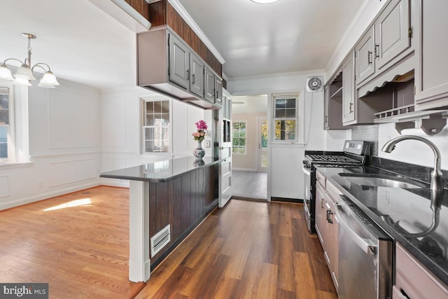 kitchen featuring a breakfast bar, sink, ornamental molding, dark hardwood / wood-style flooring, and stainless steel appliances