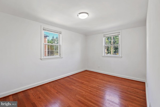 spare room with wood-type flooring and a healthy amount of sunlight