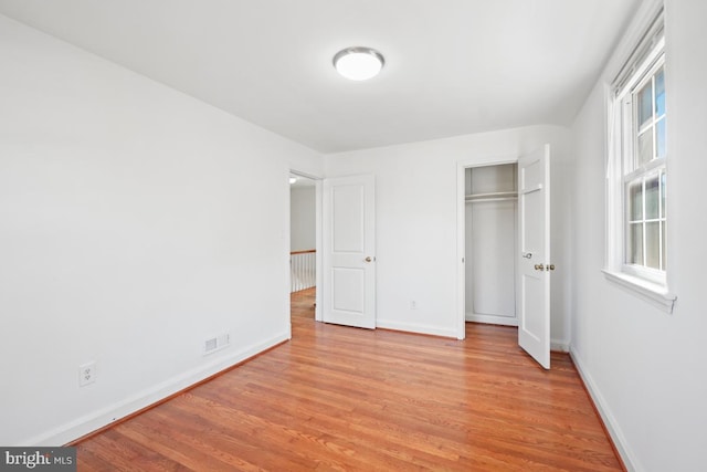 unfurnished bedroom featuring a closet and light wood-type flooring