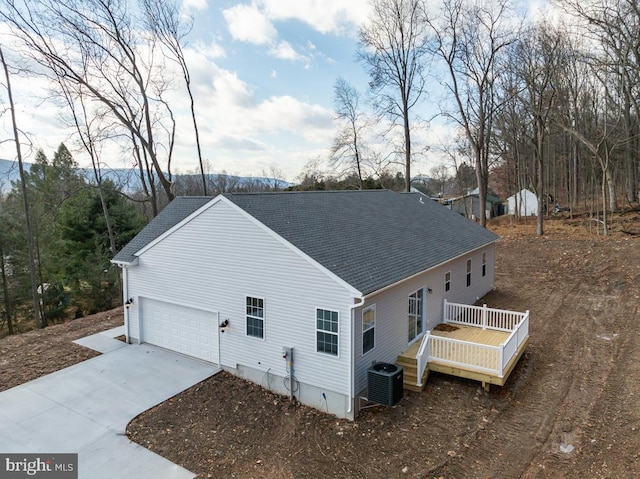 view of home's exterior featuring a wooden deck, a garage, and central AC