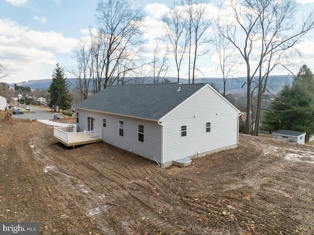 back of property with a deck with mountain view