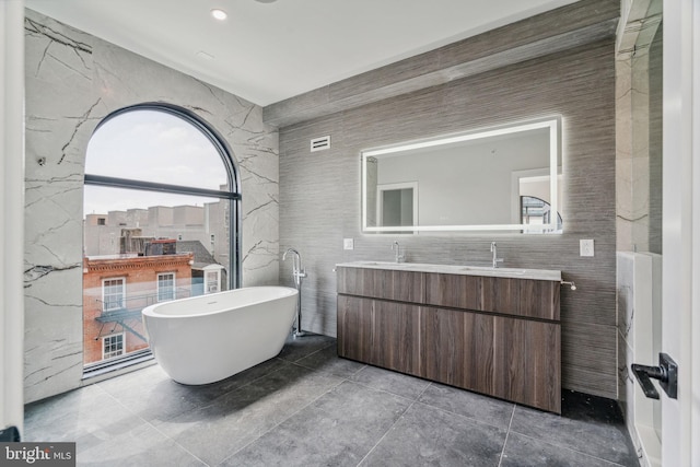 bathroom with vanity and a bath