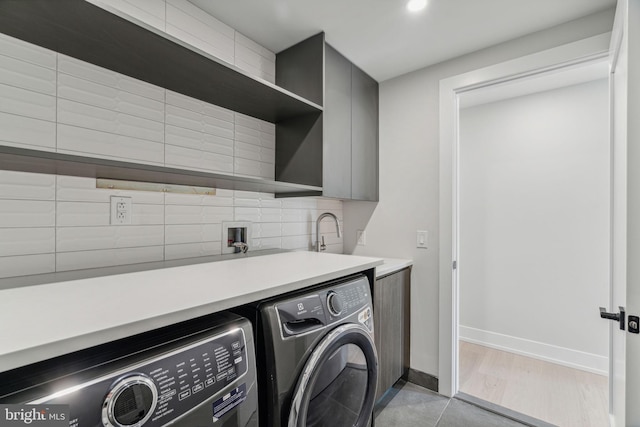 washroom featuring sink, cabinets, and washing machine and clothes dryer