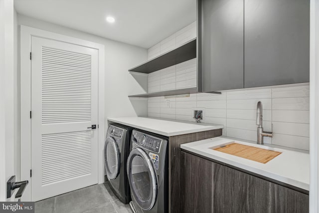 laundry room featuring independent washer and dryer, cabinets, sink, and light tile patterned floors