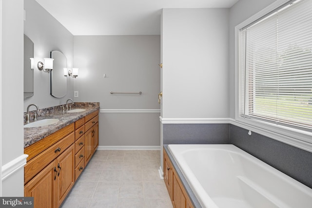 bathroom featuring vanity, tile patterned floors, and a tub