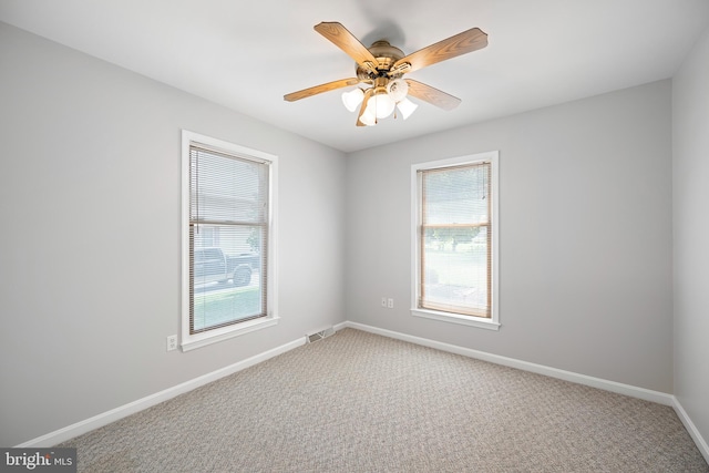 carpeted spare room featuring ceiling fan