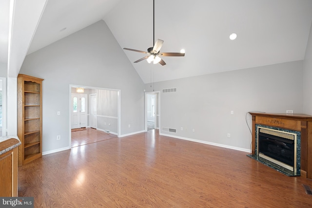 unfurnished living room with ceiling fan, wood-type flooring, and high vaulted ceiling