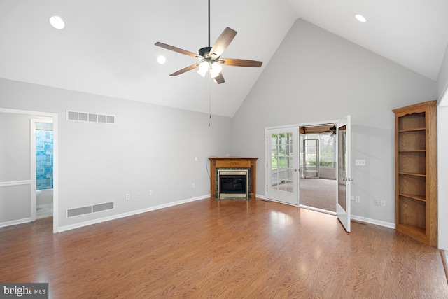 unfurnished living room with french doors, ceiling fan, wood-type flooring, and high vaulted ceiling