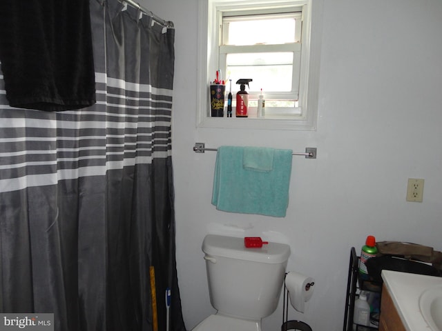 bathroom with toilet, vanity, and plenty of natural light