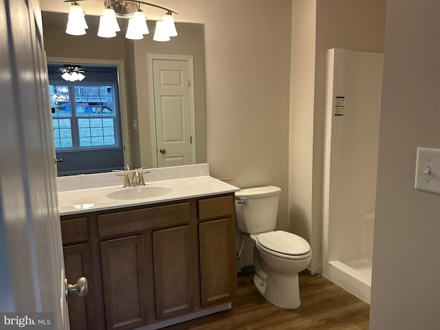 bathroom featuring walk in shower, vanity, toilet, and wood-type flooring