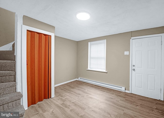 entrance foyer with a baseboard heating unit and light hardwood / wood-style floors