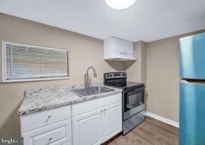 kitchen featuring stainless steel appliances, white cabinetry, hardwood / wood-style flooring, and sink