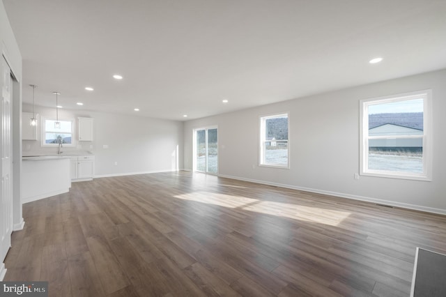 unfurnished living room featuring baseboards, wood finished floors, and recessed lighting