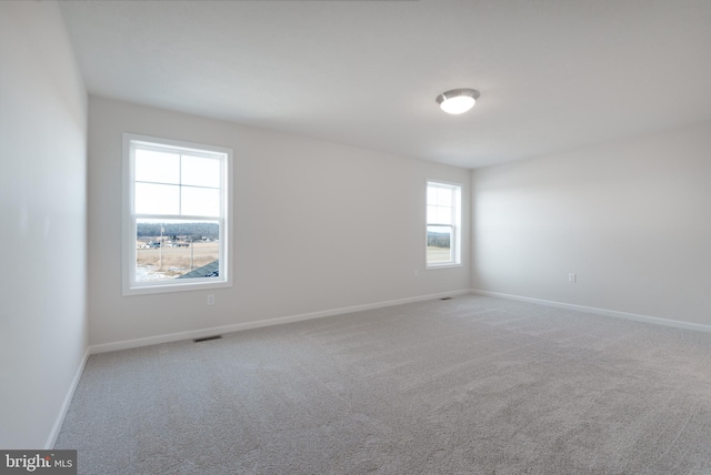 unfurnished room featuring baseboards and light colored carpet