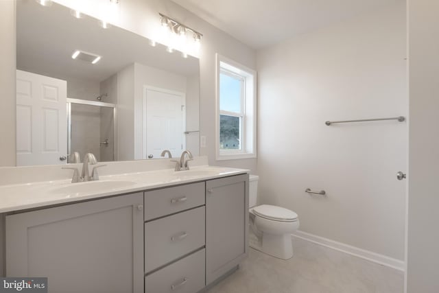 full bathroom featuring double vanity, a stall shower, a sink, and baseboards