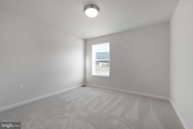 empty room with light carpet and baseboards