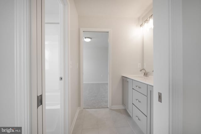 full bath with tile patterned floors, baseboards, and vanity